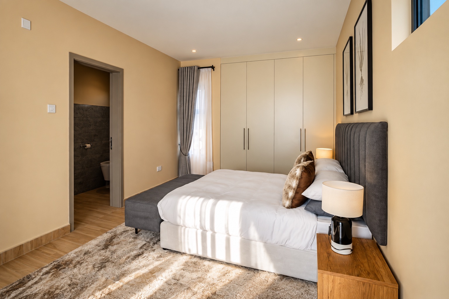 Grey upholstered bed with white linen and natural light